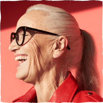 Postarší smějící se žena s brýlemi