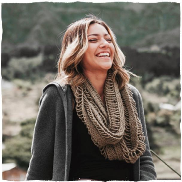 Žena s šátkem se směje v přírodě