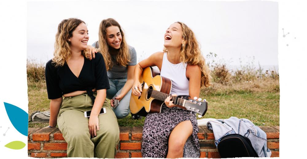 Parta dívek hraje na kytaru a zpívá