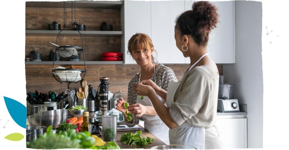 Dvě ženy spolu vaří jídlo v kuchyni