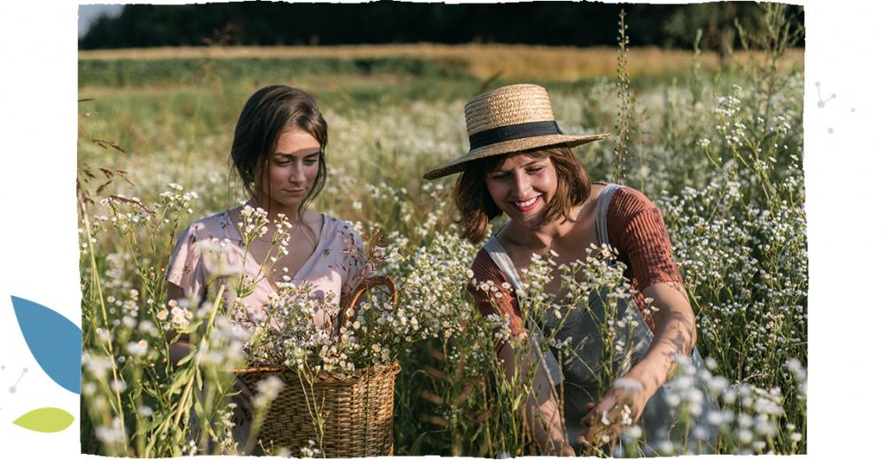 Dvě dívky sbírají květiny v lese