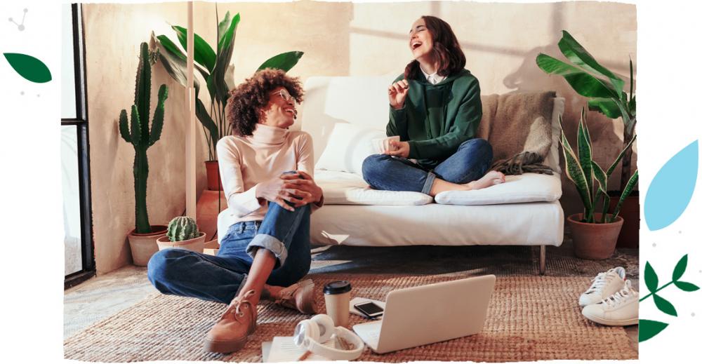 Dvě dívky sedící na gauči se spolu smějí