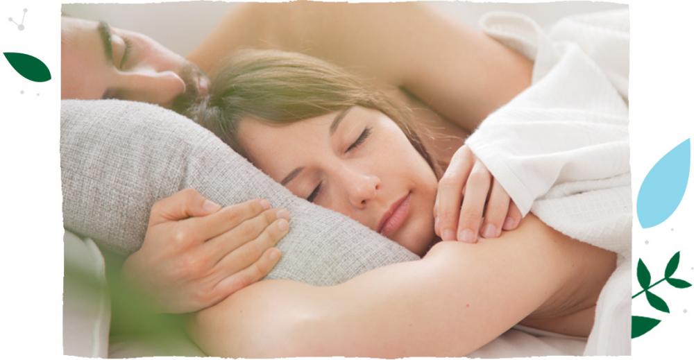 Muž a žena leží klidně v posteli a drží jeden druhého ve spánku